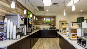 Un espace cuisine moderne équipé d’une machine à café, d’un four à micro-ondes et d’un présentoir à pain.