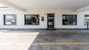 A building with a flat roof, large windows, and a concrete ground. - OYO Hotel DeRidder Hwy 171 North (DeRidder)