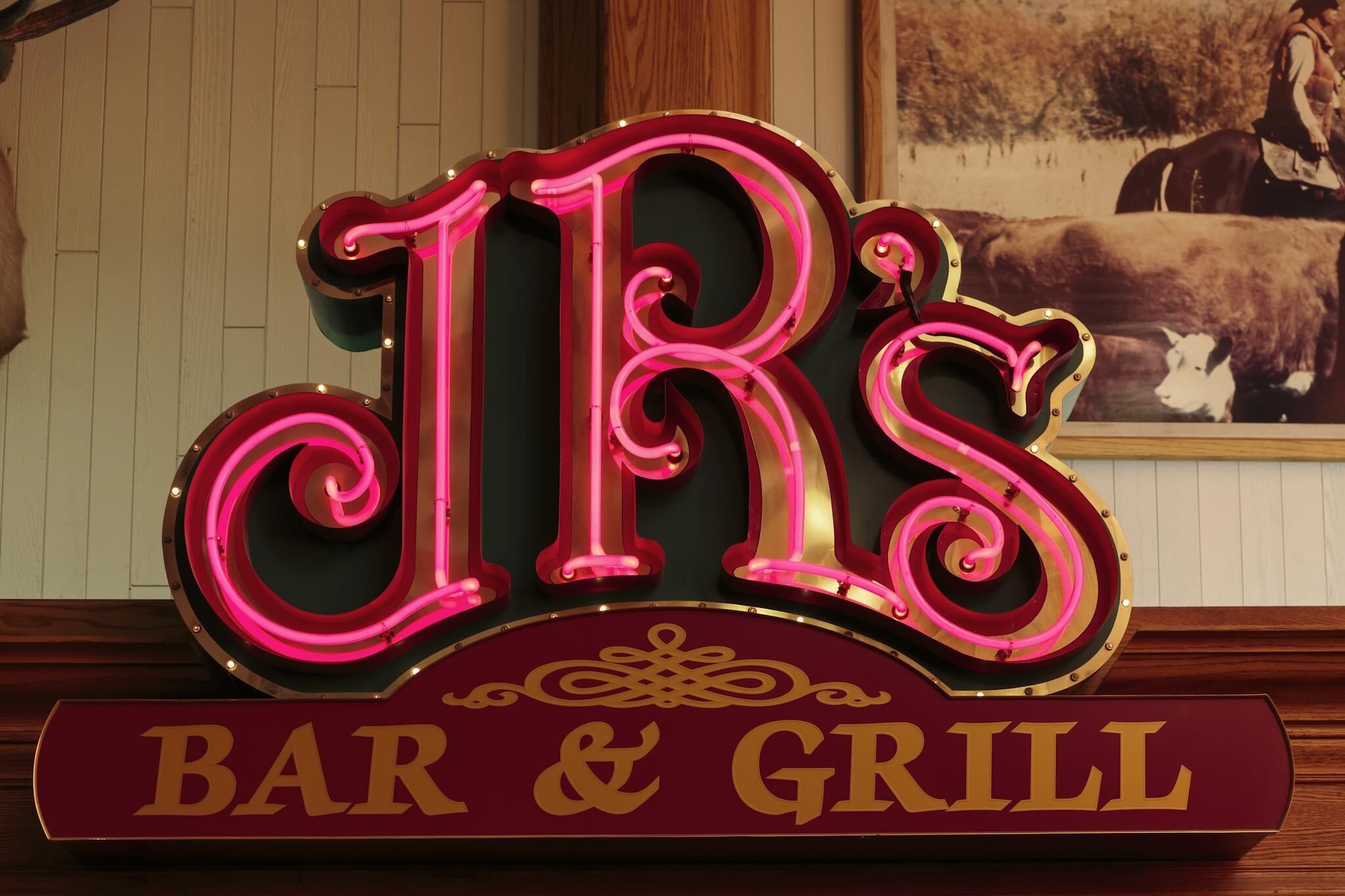 A neon sign with the letters 'JR' and 'BAR & GRILL' indicating a restaurant establishment.