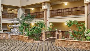 A multi-level atrium with a fountain, stone walls, and potted plants. - Radisson Hotel El Paso Airport (El Paso)