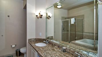 Un baño con dos lavamanos, cabina de ducha de vidrio y un espejo grande.