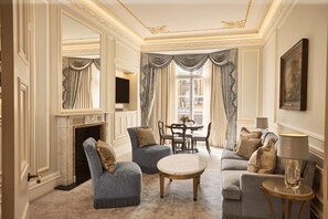 A luxurious living room with a fireplace, elegant furniture, and a large window with curtains.