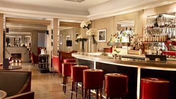 Eine Bar mit roten Barhocker, einem glatten Holzboden und einer gut sortierten Bar.
