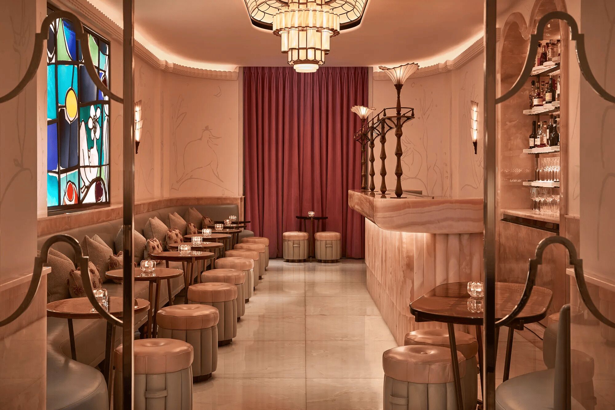 A hotel lobby with a row of seating, a bar area, and a stained glass window.