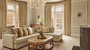 Amplia sala de estar con un sofá modular grande, una mesa de centro de madera y un candelabro.