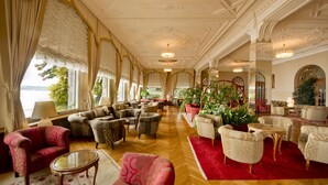 A spacious lounge with comfortable seating, large windows, and decorative plants.