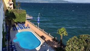 A hotel with a pool, lounge chairs, and a view of the sea. - Grand Hotel Gardone Riviera (Gardone Riviera)