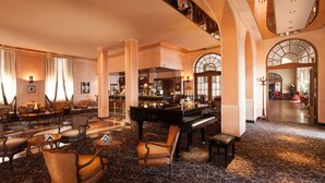 A spacious lobby with a grand piano, comfortable seating, and a bar area. - Grand Hotel Gardone Riviera (Gardone Riviera)