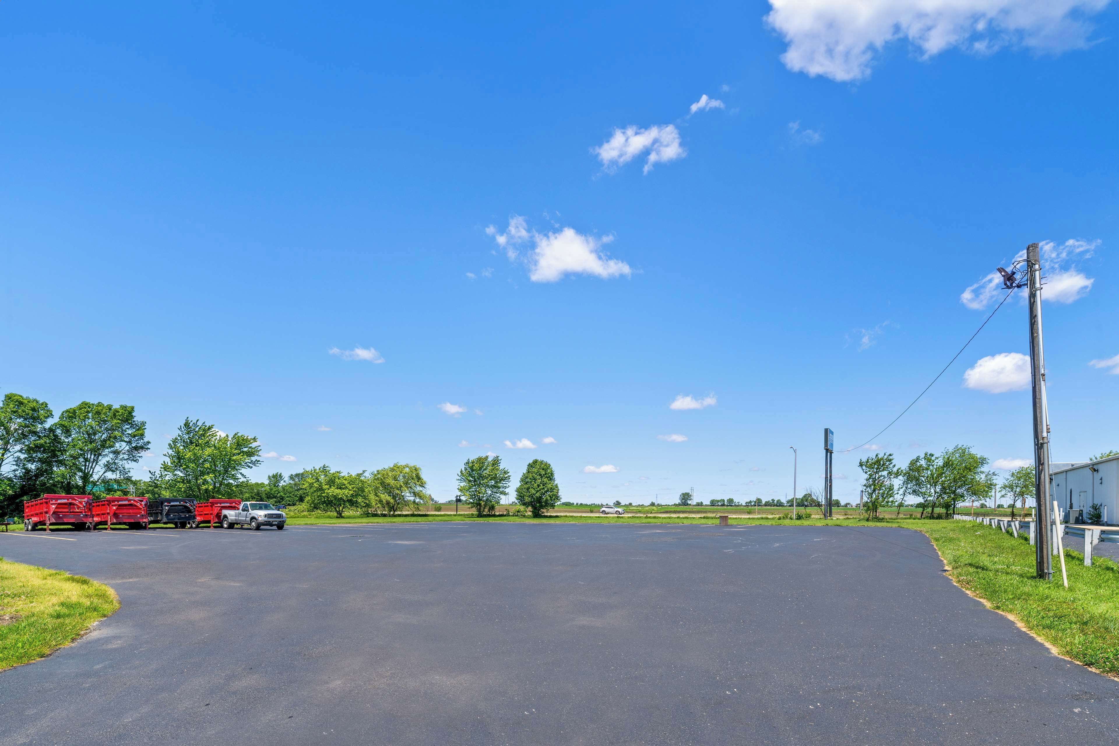 A large, open parking area with a clear sky and a few clouds.
