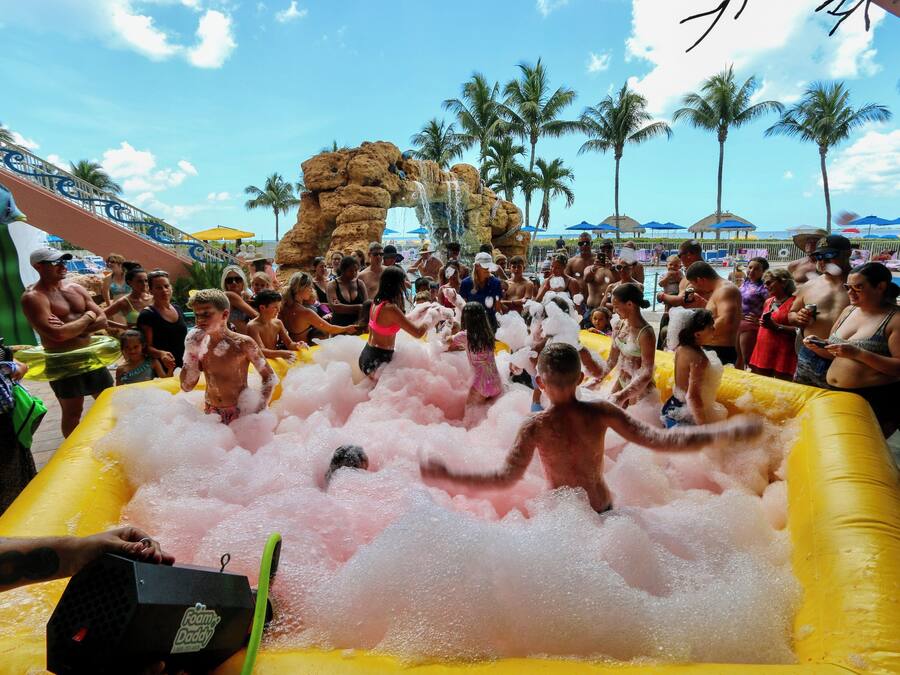 Un grupo de personas divirtiéndose en un tobogán de agua inflable gigante en un resort.