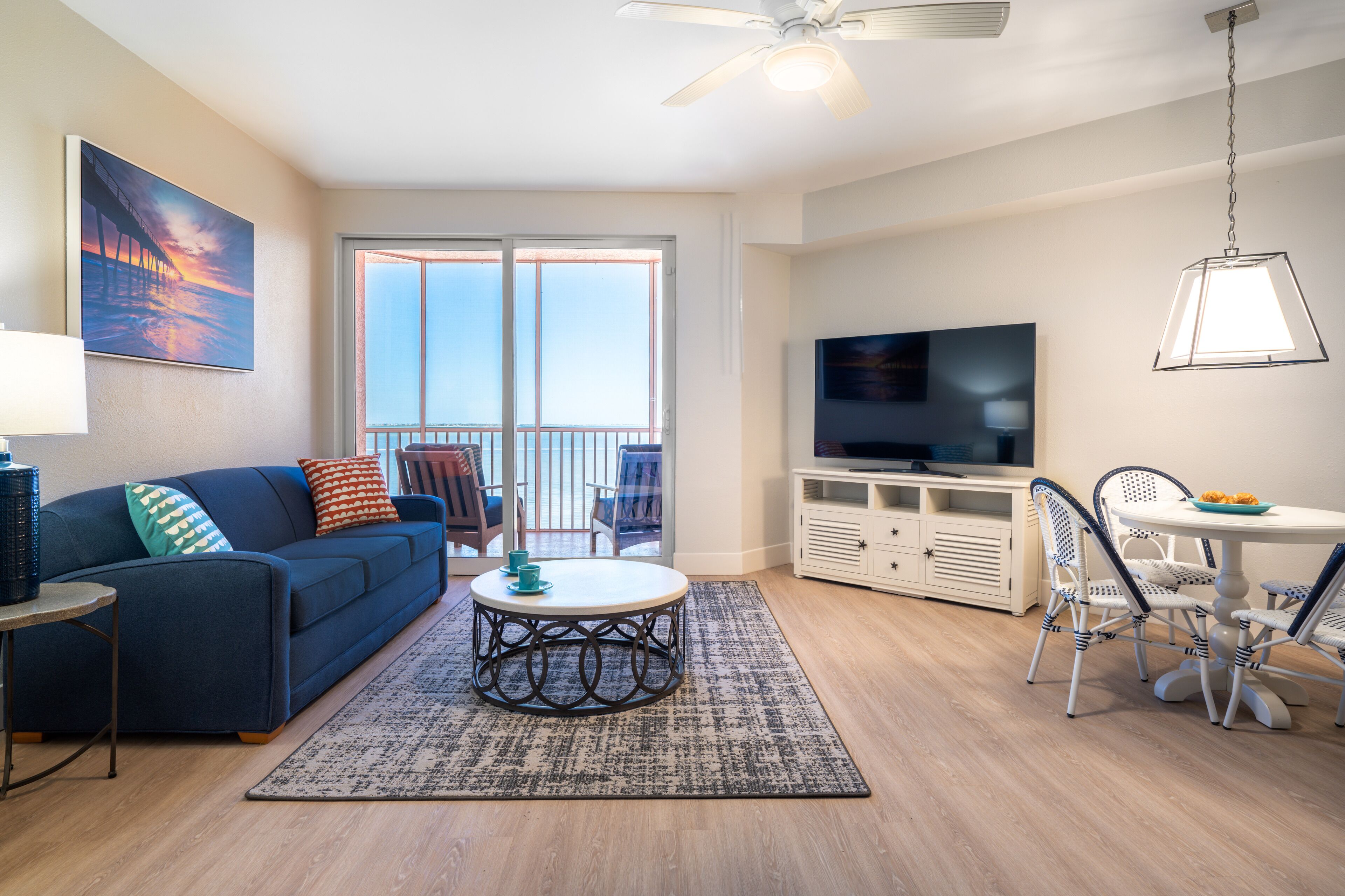 A living room with a sofa, coffee table, TV, and dining area with chairs.
