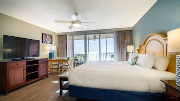 Une chambre d’hôtel avec un grand lit, un bureau avec une chaise, une télévision et un balcon avec vue.