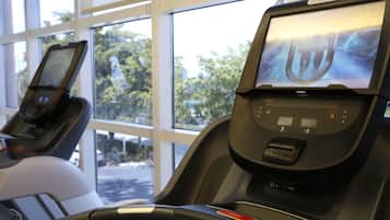 A gym with treadmills and a large window.