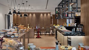 Een moderne keuken met een lange toonbank, verschillende etenswaren en een barruimte met planken.