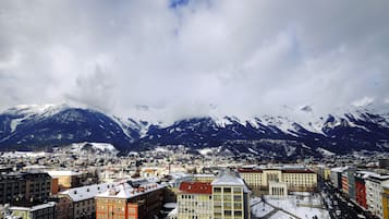 Un paisaje urbano con montañas nevadas al fondo, que presenta una mezcla de arquitectura tradicional y moderna.