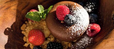 A dessert with berries and powdered sugar on a wooden surface.