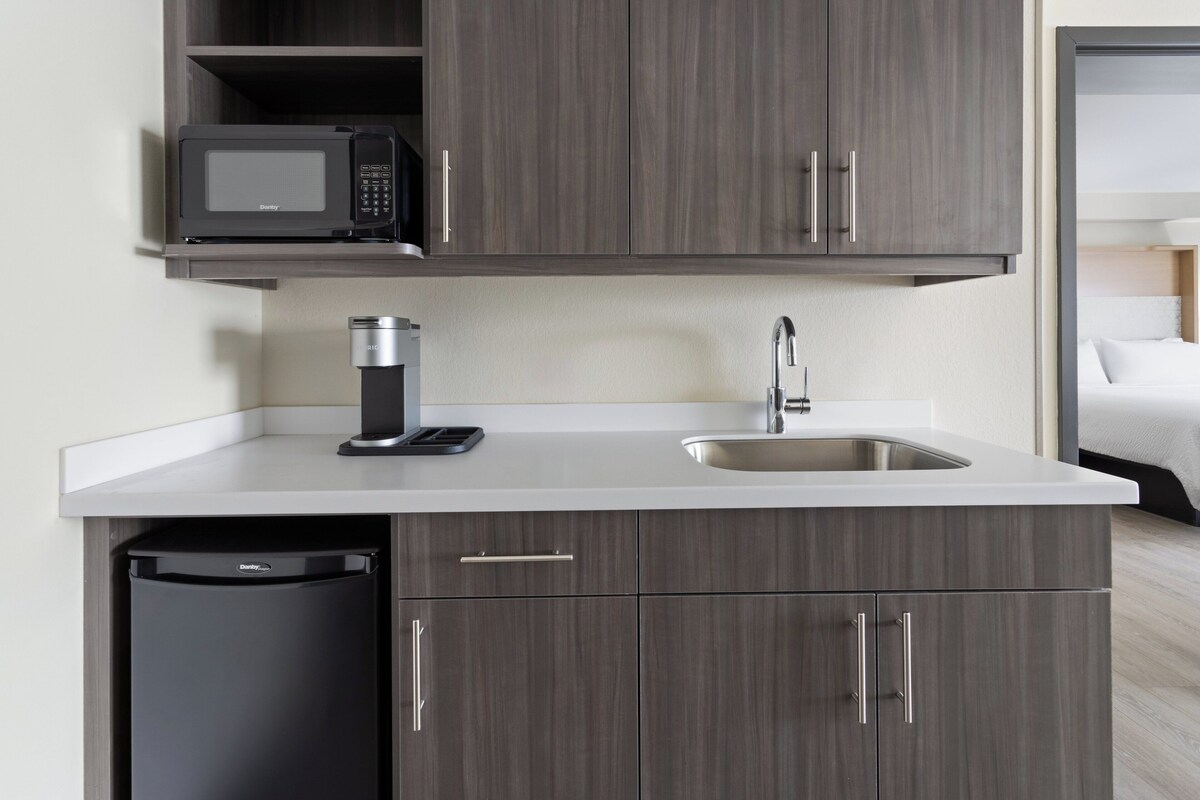 Una cucina compatta con microonde, lavello e lavastoviglie.