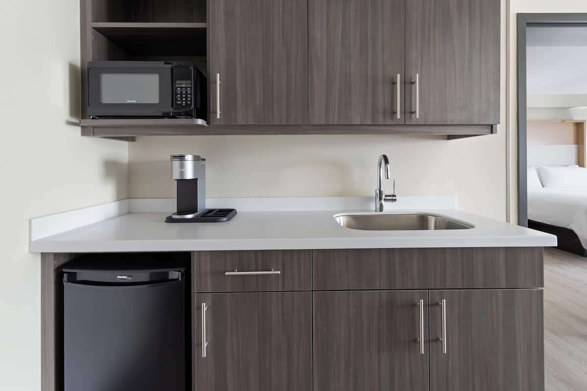 A compact kitchen with a microwave, sink, and dishwasher.