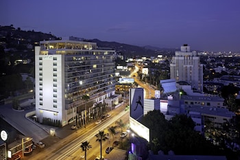 A modern lobby with a staircase, leather seating, a coffee table, and a view of the street. at ANDAZ WEST HOLLYWOOD, BY HYATT