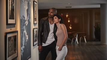 Una pareja de pie en una galería con obras enmarcadas en las paredes.
