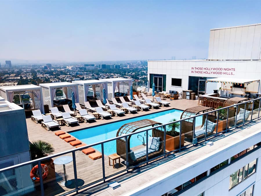 Una piscina al aire libre, camas de piscina gratis, sombrillas