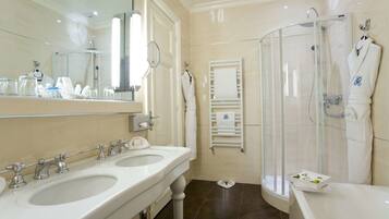 A bathroom with two sinks, a shower, and a bathtub.