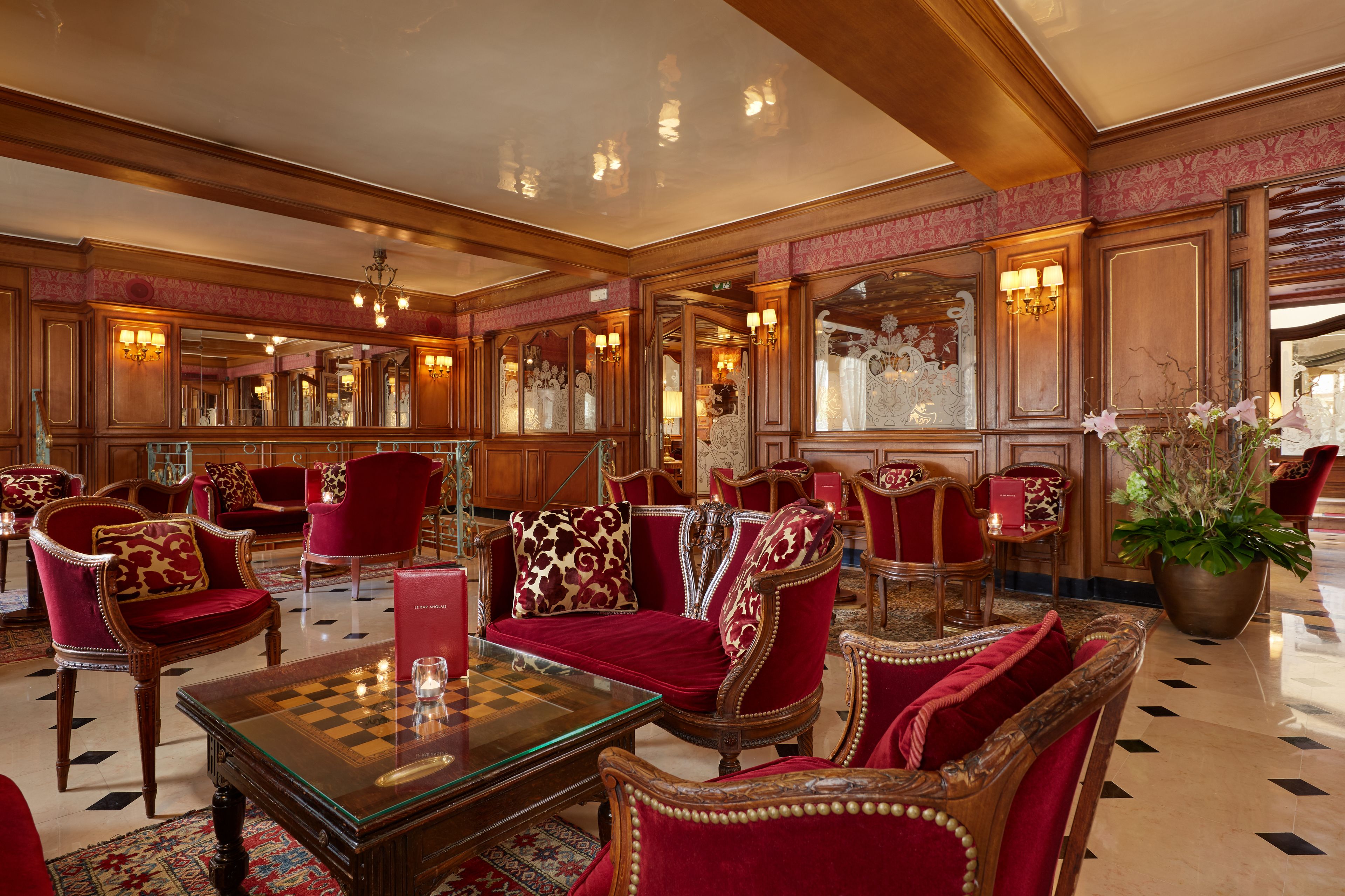 A luxurious lobby with ornate furniture, a chess table, and a large potted plant.