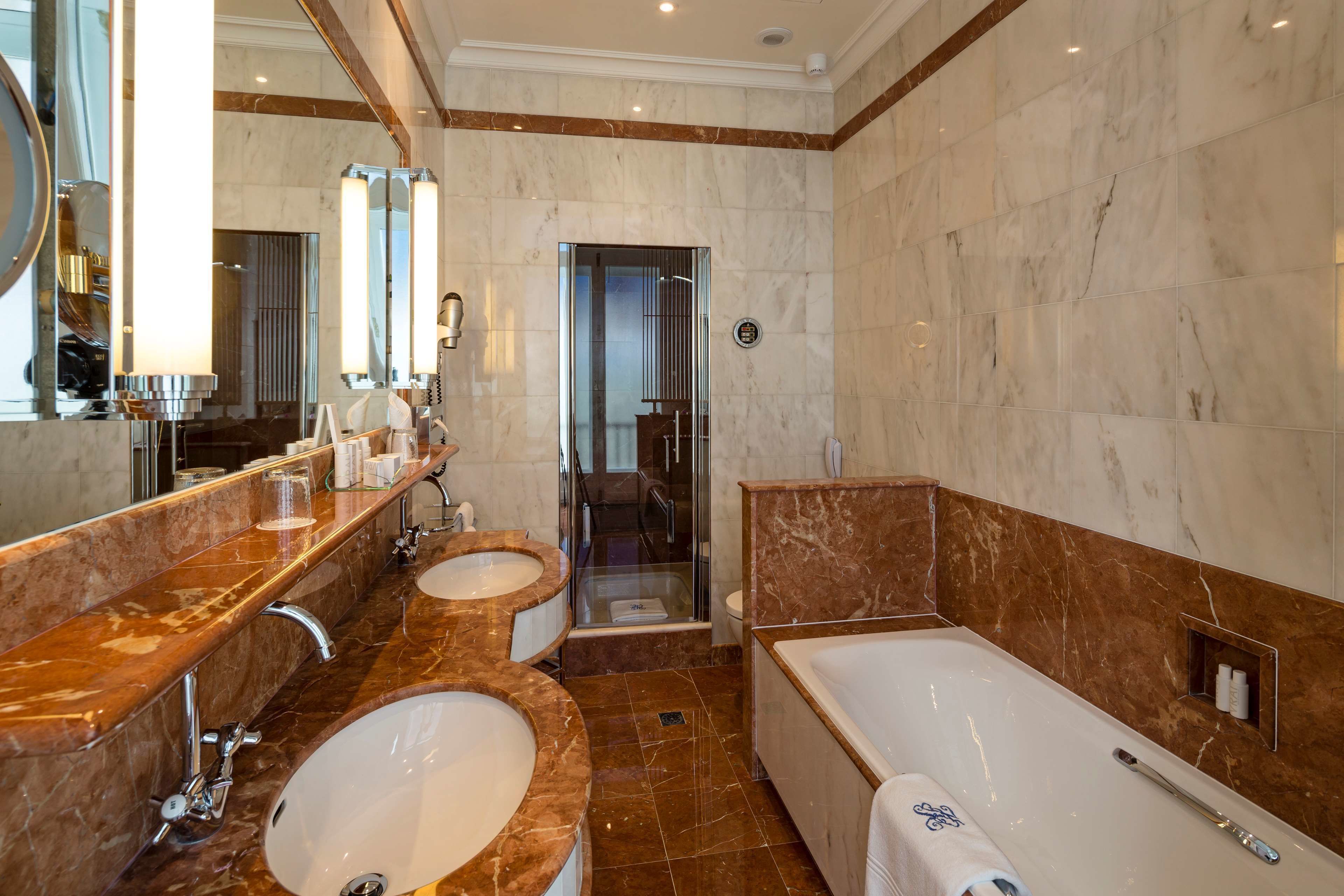 Ein luxuriöses Badezimmer mit zwei Waschbecken, einer großen Badewanne und einer begehbaren Dusche.