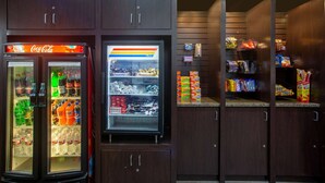 A vending machine area with Coca-Cola and other beverages, snacks, and a freezer.