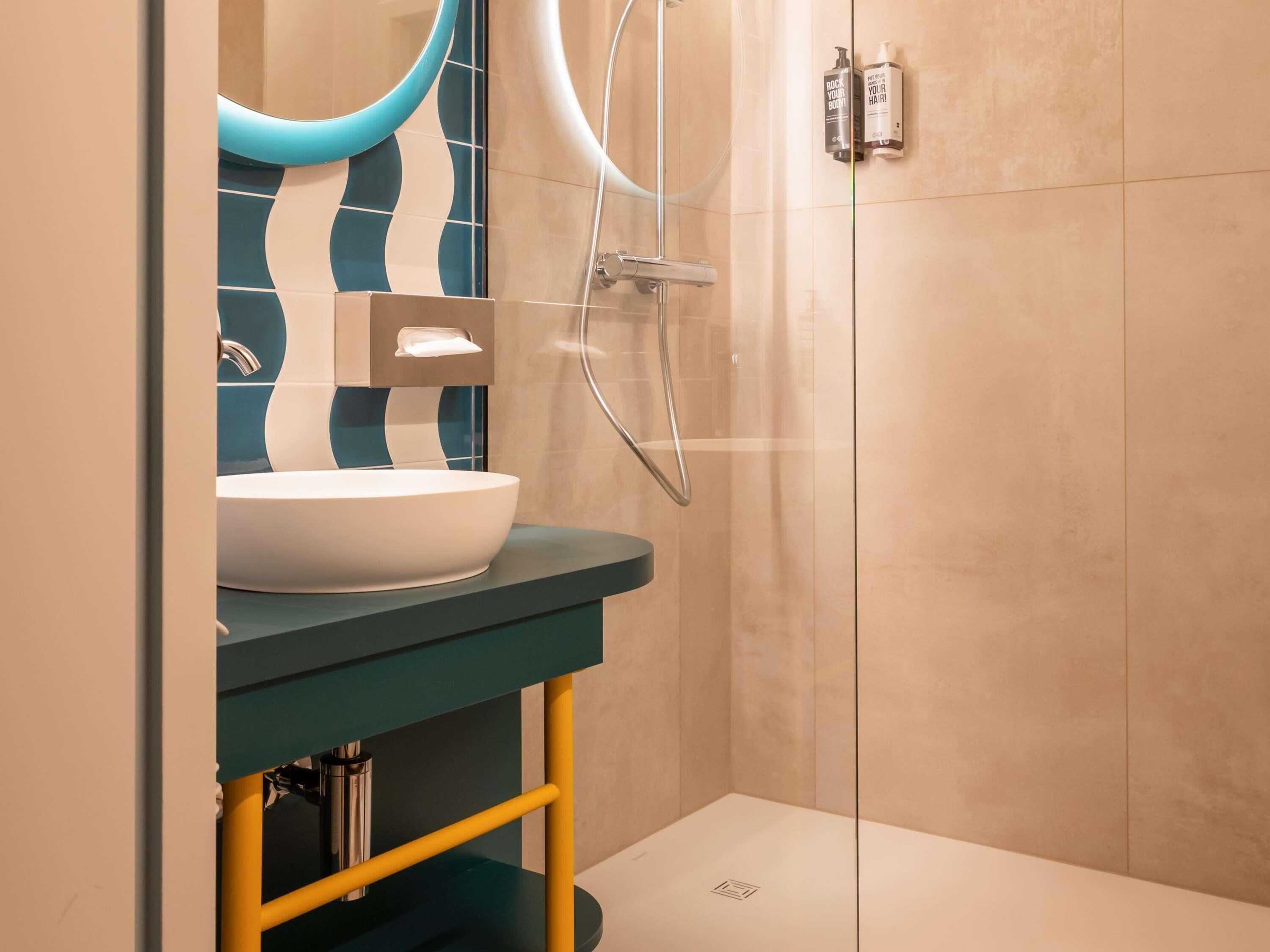 Un baño moderno con un lavamanos grande, ducha y espejo.