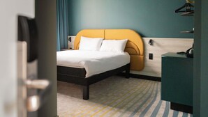 A hotel room with a bed, a desk, and a striped carpet. - ibis Styles Brugge Centrum (Bruges)
