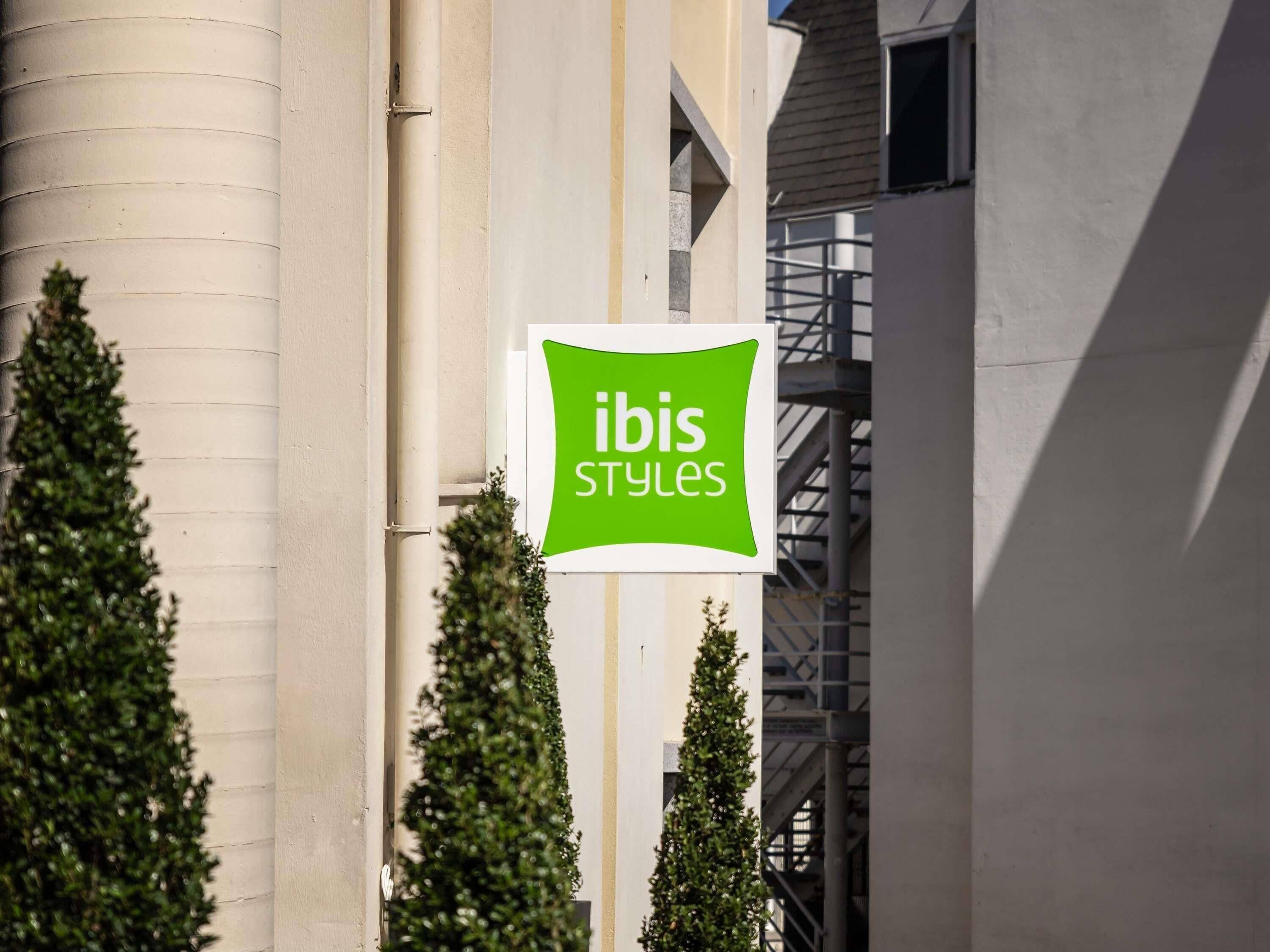 Une enseigne « ibis Styles » fixée à un bâtiment.
