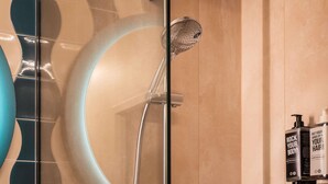 A modern bathroom with a glass shower enclosure, a curved wall design, and a wall-mounted shampoo dispenser. - ibis Styles Brugge Centrum (Bruges)