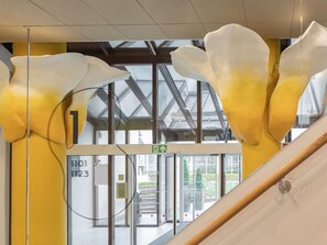 A modern interior with a glass door entrance, a visible exit sign, and a metal structure. - ibis Styles Brugge Centrum (Bruges)