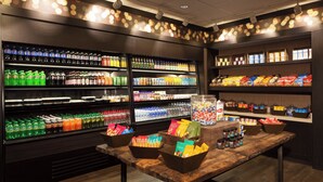 A well-lit beverage and snack display area with various drinks and snacks. - Sheraton Bucks County Langhorne (Langhorne)