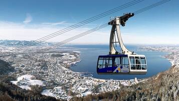 Eine Seilbahn mit freiem Blick auf eine Stadt und einen See darunter.