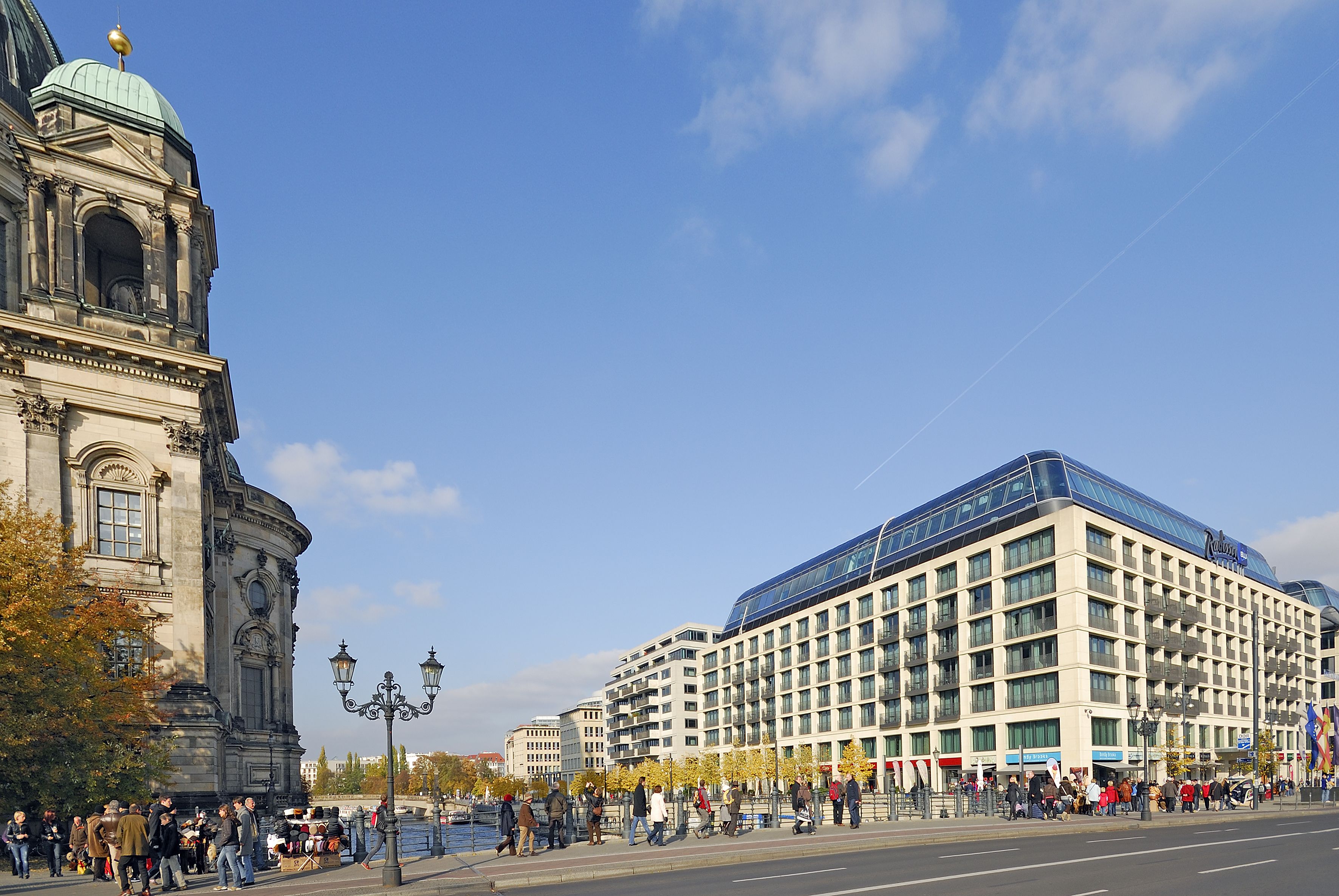 Ein historisches Gebäude mit einer Kuppel und ein modernes Hotel mit einer Glasfassade.