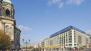Ein historisches Gebäude mit einer Kuppel und ein modernes Hotel mit einer Glasfassade.