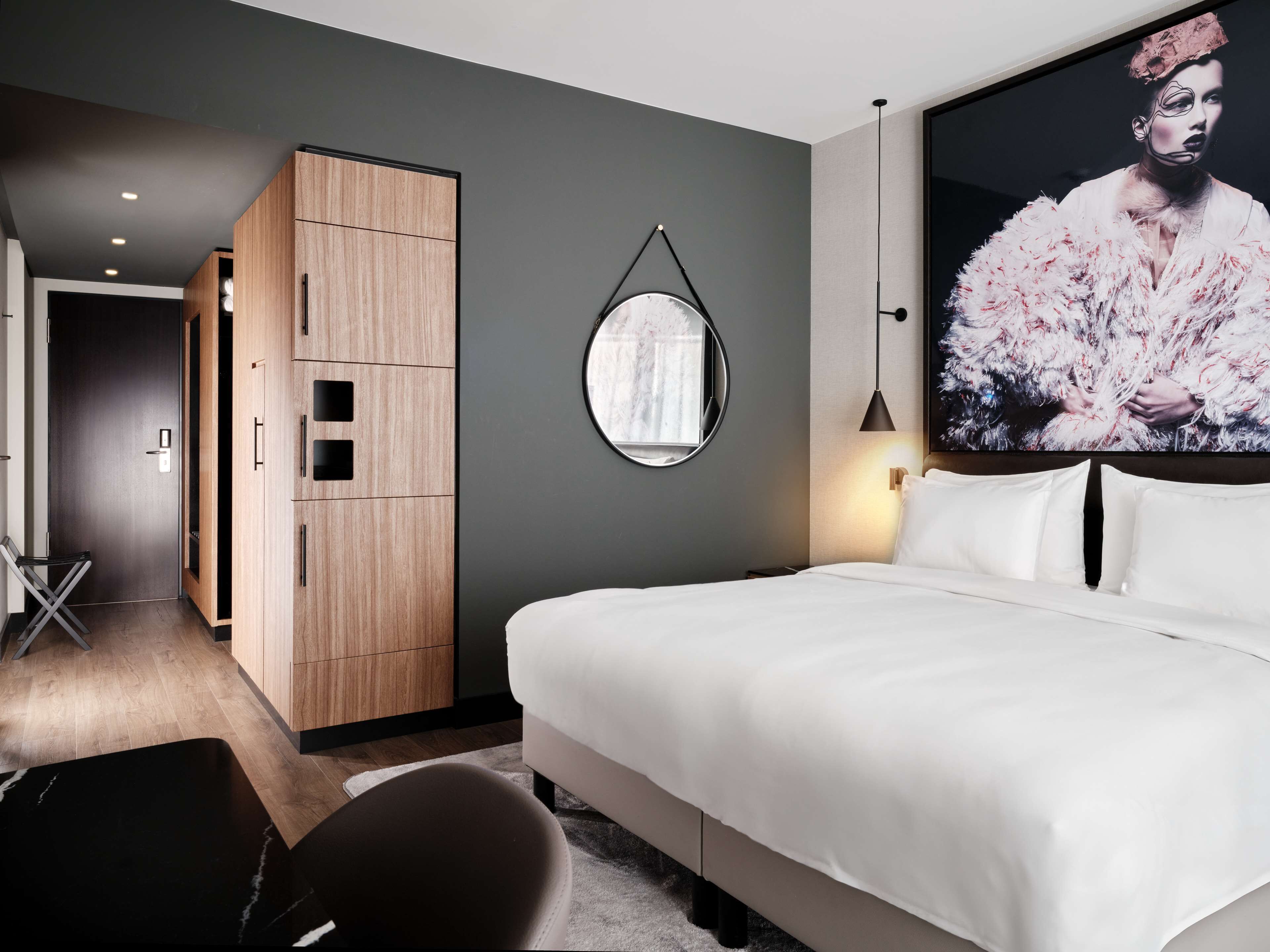 Una camera da letto moderna con un letto grande, un armadio, uno specchio e una TV a parete.