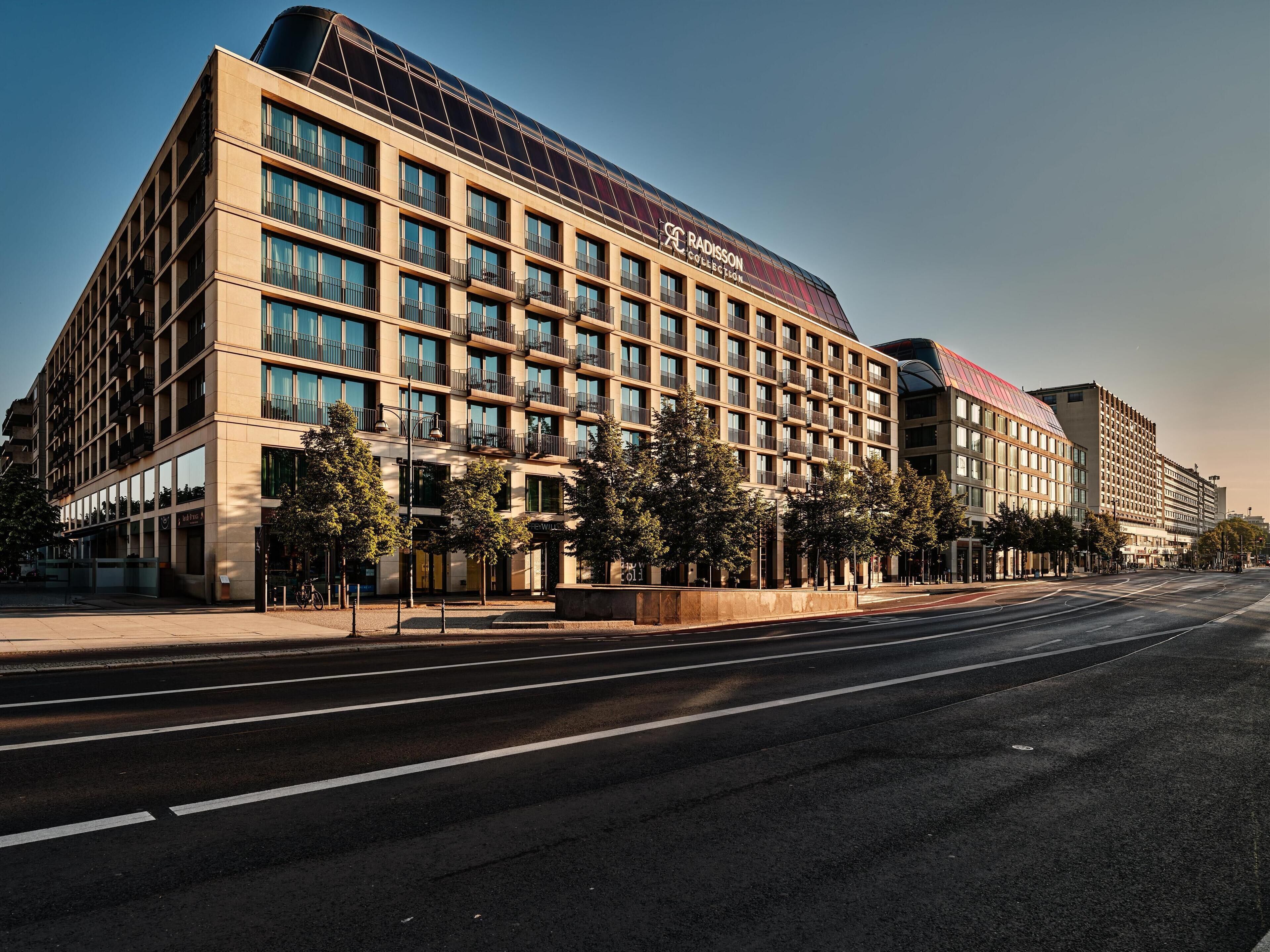 Ein modernes Hotel mit einer großen Glasfassade, mehreren Balkonen und einer auffälligen Beschilderung.
