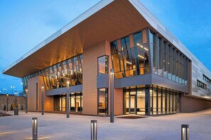 A modern building with large glass windows and a flat roof. - Delta Hotels by Marriott Muskegon Convention Center (Muskegon)