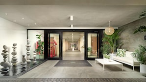 Un hall d’entrée moderne avec un comptoir d’accueil, une fontaine et des plantes d’intérieur.