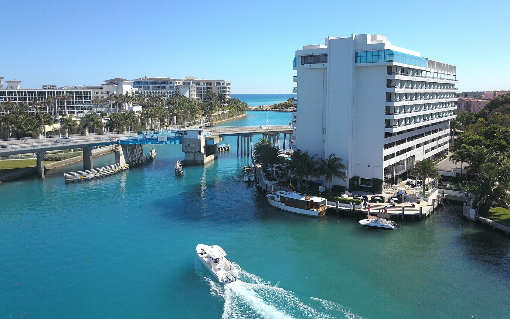 Um hotel à beira-mar com marina, uma ponte e uma piscina.