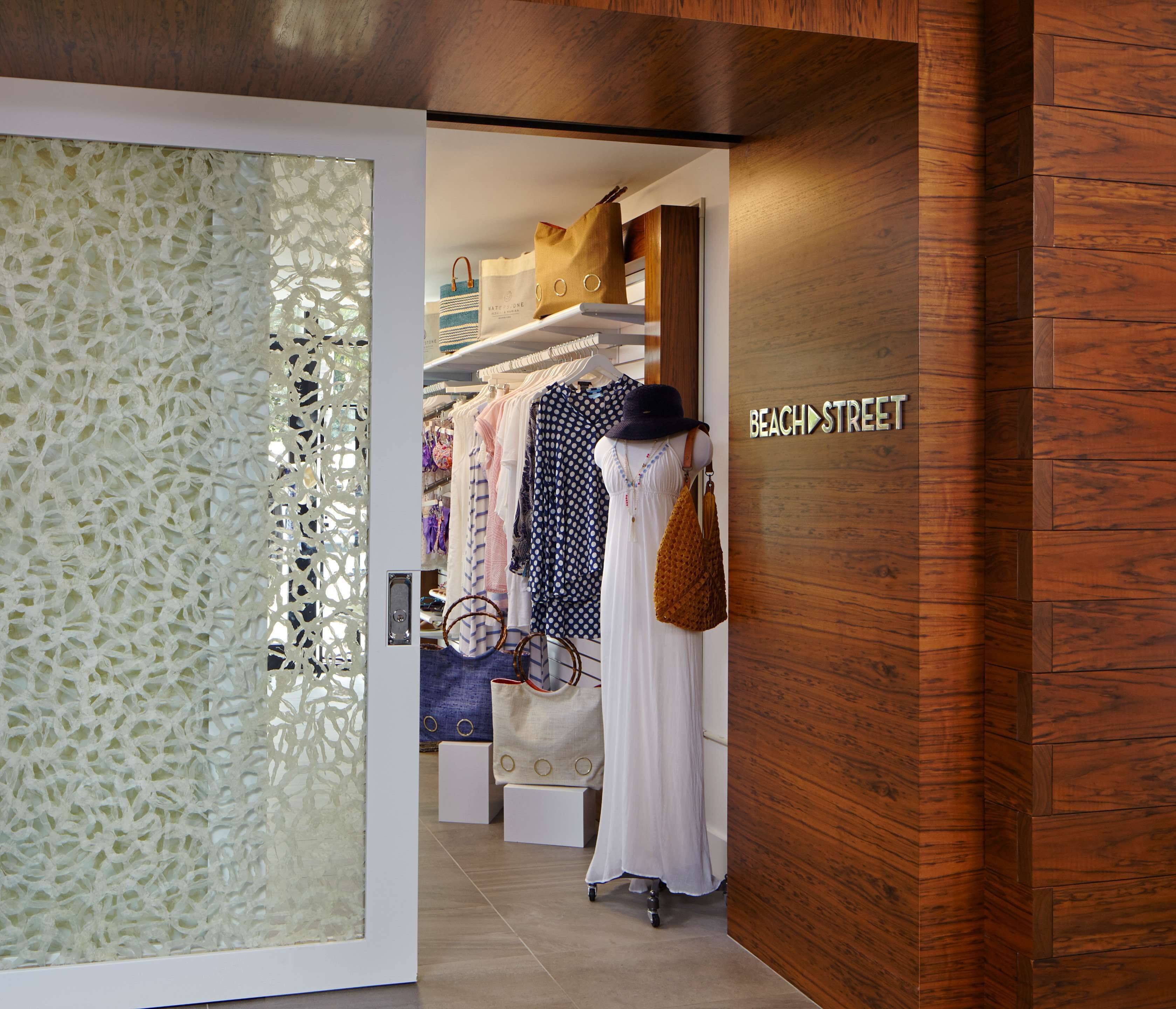 A store interior with wooden paneling, a mannequin dressed in a white dress, and a sign reading "BEACH STREET".