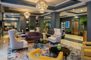 A spacious lobby with a chandelier, comfortable seating, and a modern design.