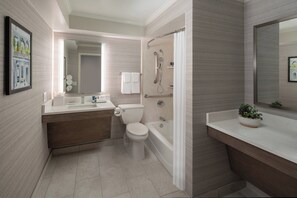 A modern bathroom with a toilet, sink, bathtub, and shower. - Four Points By Sheraton French Quarter (New Orleans)