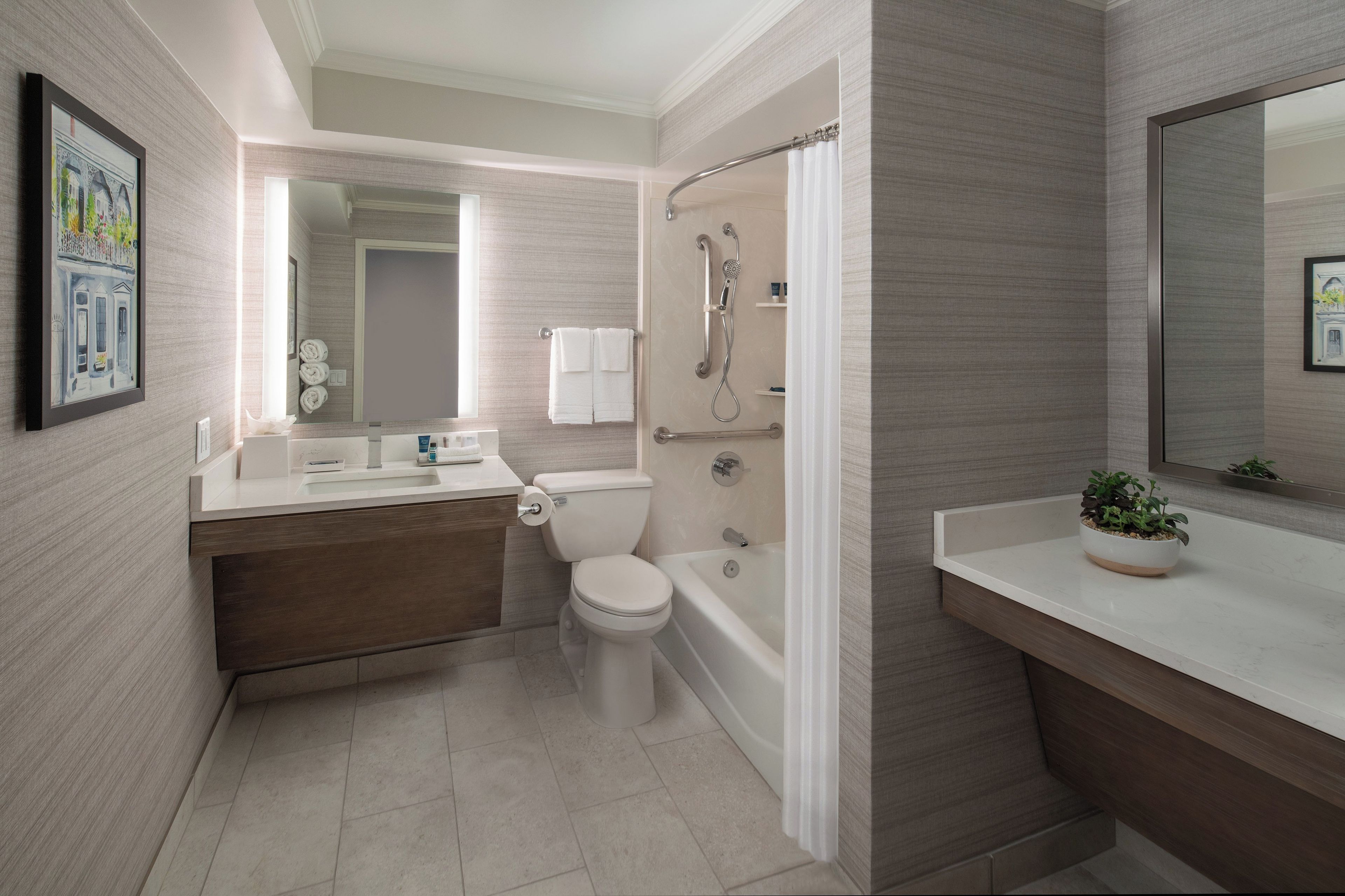 A modern bathroom with a toilet, sink, bathtub, and shower.