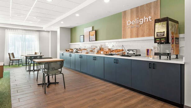 A modern kitchen area with a counter, seating, and a coffee machine. - Spark by Hilton Hummelstown Hershey (Hummelstown)