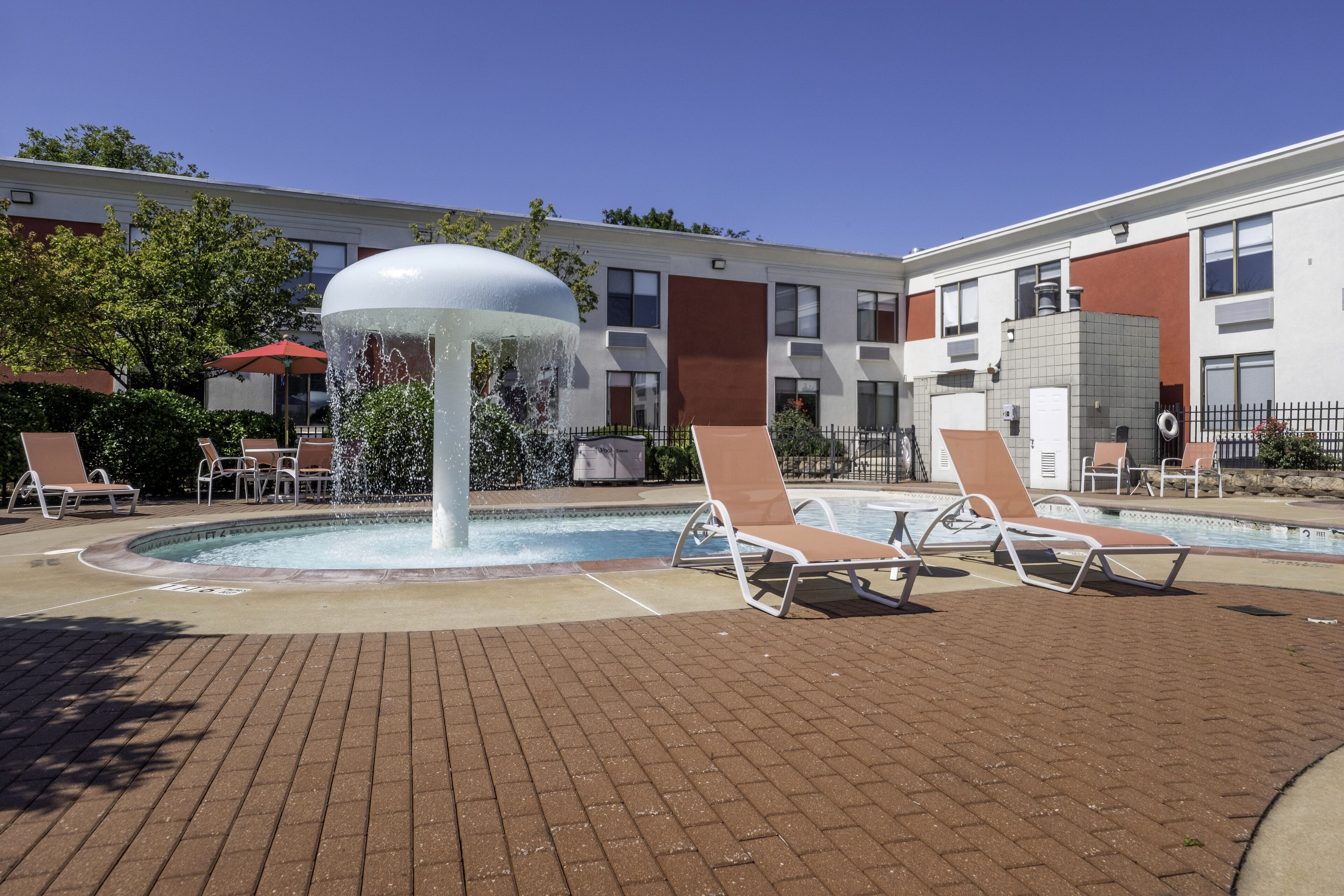 Uma área de piscina com espreguiçadeiras e uma fonte de água.