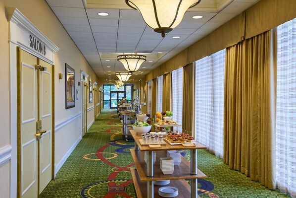 A hotel corridor with a green patterned carpet, a buffet table with food, and a sign for 'SALON B'. - Washington Dulles Airport Marriott (Sterling)